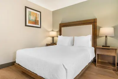 a bedroom with a large white bed with two lamps at Best Western PLUS Burnaby Hotel in Burnaby