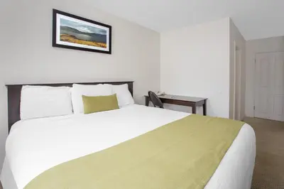 a bedroom with a large white bed and a table at Barriere Motor Inn-BMI in Barrière