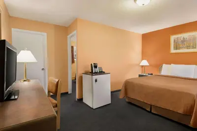 a hotel room with a bed and a television at Travelodge by Wyndham Quesnel BC in Quesnel