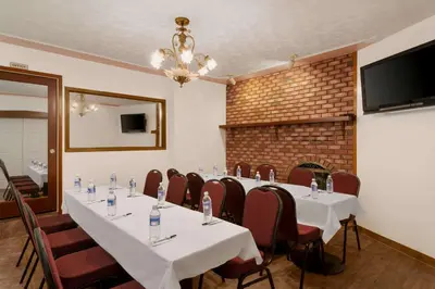 a conference room with tables and chairs and a fireplace at Travelodge by Wyndham Quesnel BC in Quesnel