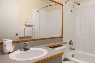 a bathroom with a sink and a toilet and a tub at Travelodge by Wyndham Quesnel BC in Quesnel