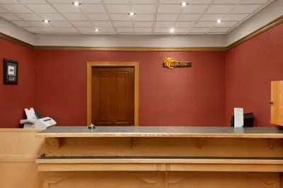 a waiting room with a counter and red walls at Travelodge by Wyndham Quesnel BC in Quesnel