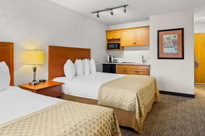 a hotel room with two beds and a kitchen at Best Western PLUS Langley Inn in Langley