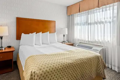 a hotel room with a large bed and a window at Best Western PLUS Langley Inn in Langley