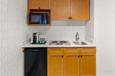 a kitchen with a sink and a stove and a microwave at Best Western PLUS Langley Inn in Langley