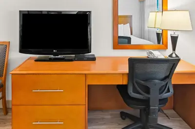 a desk with a computer and a monitor and a chair at Best Western PLUS Langley Inn in Langley