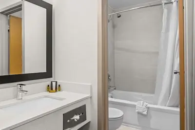 a bathroom with a sink and a toilet and a mirror at Best Western PLUS Langley Inn in Langley