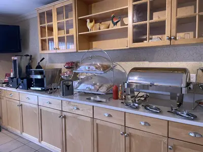 a kitchen with wooden cabinets and a counter top at Best Western PLUS Langley Inn in Langley