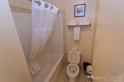 a bathroom with a tub and a toilet and a shower at Empire Inn & Suites in Red Deer