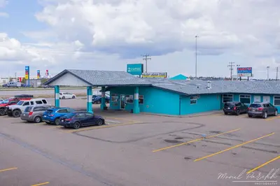 a gas station with cars parked in a parking lot at Empire Inn & Suites in Red Deer