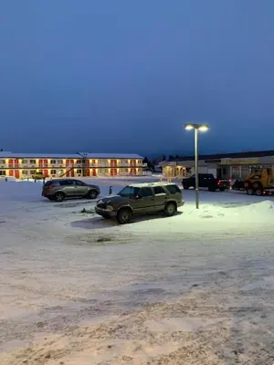a parking lot with cars parked in front of a building at Red Deer Inn & Suites in Red Deer