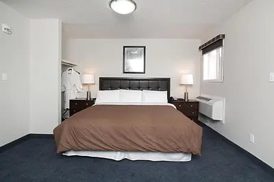 a bedroom with a large bed and two night stands at Travelodge by Wyndham Wetaskiwin in Wetaskiwin