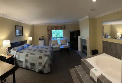 a hotel room with a bed and a bath tub at Canadian Inn in Surrey