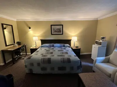a hotel room with a bed and a chair at Canadian Inn in Surrey