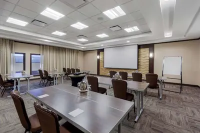 a conference room with tables and chairs and a whiteboard at Best Western Plus Edmonton Airport Hotel in Leduc