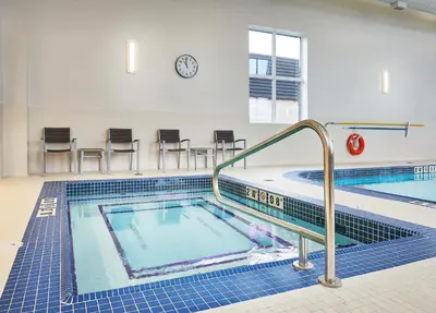 a swimming pool in a building with a clock on the wall at Best Western Plus Edmonton Airport Hotel in Leduc