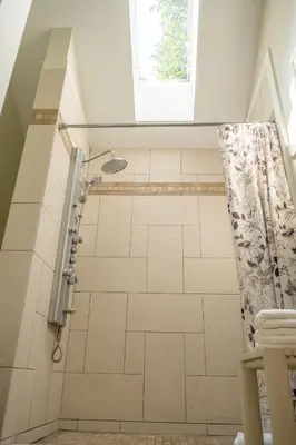 a bathroom with a shower with a shower curtain at CHATHAM HOUSE Kelowna Bed & Breakfast in Kelowna
