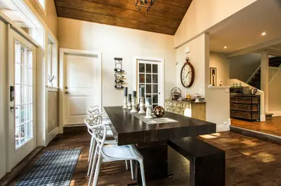 a dining room with a black table and white chairs at CHATHAM HOUSE Kelowna Bed & Breakfast in Kelowna