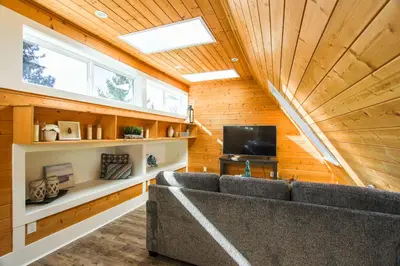 a living room with a couch and a television at CHATHAM HOUSE Kelowna Bed & Breakfast in Kelowna