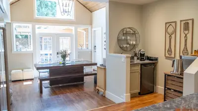 a kitchen with a table and a dining room at CHATHAM HOUSE Kelowna Bed & Breakfast in Kelowna