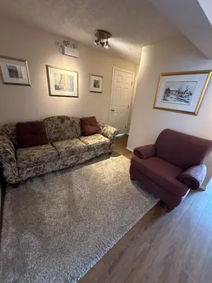 a living room with a couch and a chair at Burns Lake Bed and Breakfast in Burns Lake