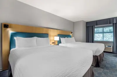 a hotel room with two beds and a window at Clarion Hotel & Conference Centre in Abbotsford
