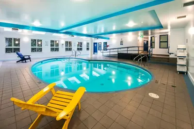 a pool with a yellow chair and a chair in a hotel room at Clarion Hotel & Conference Centre in Abbotsford