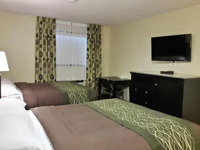 a hotel room with two beds and a flat screen tv at Lacombe Motor Inn in Lacombe