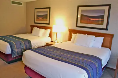 a hotel room with two beds and a lamp at Harrison Hot Springs Resort & Spa in Harrison Hot Springs