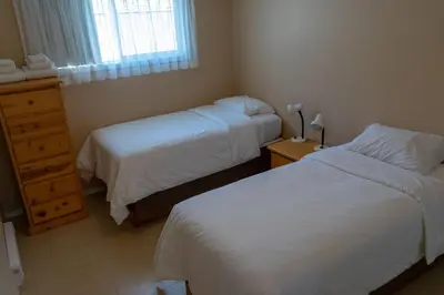 a hotel room with two beds and a window at Sandy Beach Suites in Osoyoos
