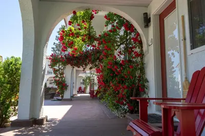 an archway with red flowers on a building at Sandy Beach Suites in Osoyoos