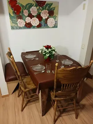 a dining room table with chairs and a vase of flowers at Higgin's Inn in Powell River