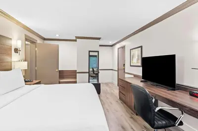 a hotel room with a bed and a flat screen tv at Best Western Maple Ridge in Maple Ridge District Municipality