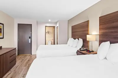 a hotel room with two beds and a television at Best Western Maple Ridge in Maple Ridge District Municipality