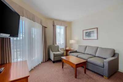 a living room with a couch and a chair in a hotel room at Best Western PLUS Chemainus Inn in Chemainus