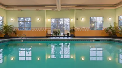 a pool in a hotel room with windows and a table at Best Western PLUS Chemainus Inn in Chemainus