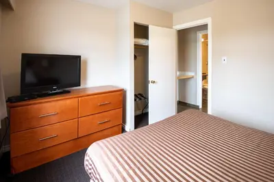 a bedroom with a bed and a television on a dresser at Canadas Best Value Inn-Prince George in Prince George