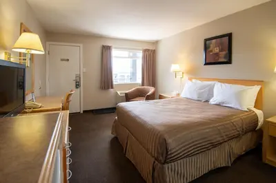 a hotel room with a bed and a flat screen tv at Canadas Best Value Inn-Prince George in Prince George