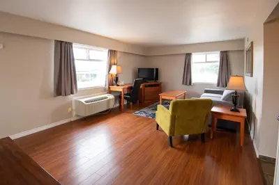 a living room with a couch and a chair and a desk at Canadas Best Value Inn-Prince George in Prince George