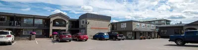 a parking lot with cars parked in front of buildings at Canadas Best Value Inn-Prince George in Prince George