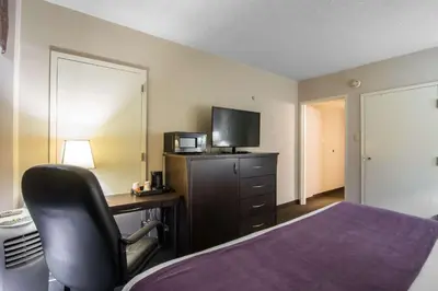 a hotel room with a bed and a desk and a chair at Quality Inn & Suites Yellowknife in Yellowknife