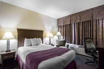 a hotel room with a bed and a chair at Quality Inn & Suites Yellowknife in Yellowknife