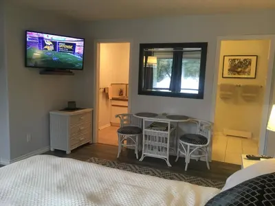 a bedroom with a bed and a tv on the wall at Long Lake Waterfront Bed and Breakfast in Nanaimo