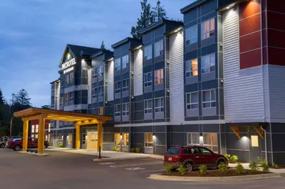 a large building with a car parked in a parking lot at Microtel Inn & Suites by Wyndham Oyster Bay Ladysmith in Ladysmith