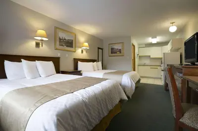 a hotel room with two beds and a television at Ramada Merritt in Merritt