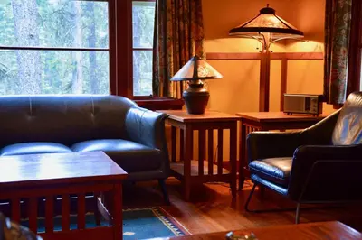 a living room with a couch and chairs and a window at Johnston Canyon Lodge & Bungalows in Castle Junction