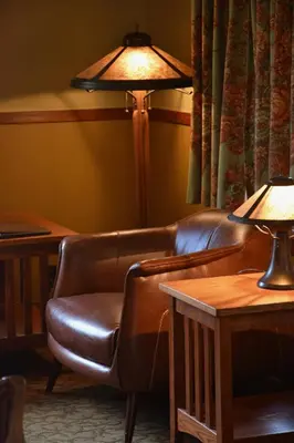 a living room with a leather couch and a lamp at Johnston Canyon Lodge & Bungalows in Castle Junction