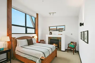 a bedroom with a bed and a fireplace at Black Rock Ridge in Ucluelet