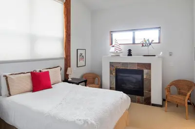a bedroom with a bed and a fireplace at Black Rock Ridge in Ucluelet