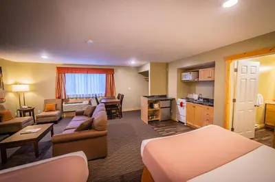 a living room with a couch and a kitchen at Alpine Inn & Suites in Nelson